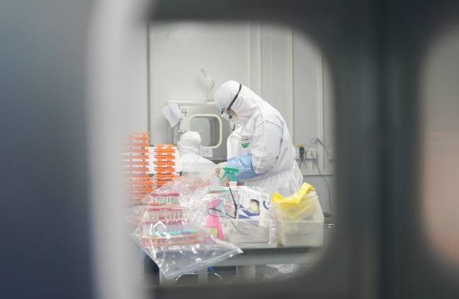 工作人员在湖北省武汉新型冠状病毒检测实验室处理核酸试验样品。信用：PA